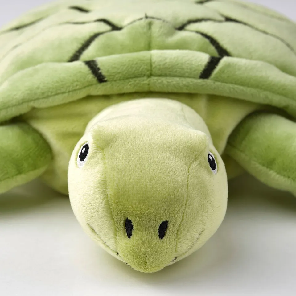 Stuffed sea turtle toy, soft green fabric, black eyes, small nose, and realistic shell texture.
