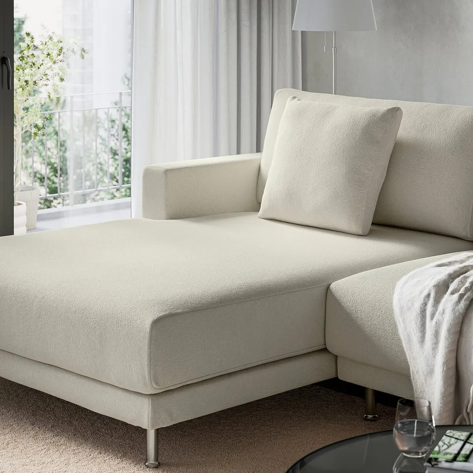 A modern, white UPPÅKRA sofa with deep cushions and a cosy design sits near a window, offering a comfortable spot for relaxation.
