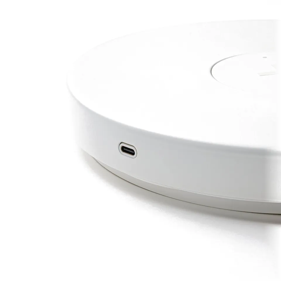 Round, white wireless charger with sleek design. Usb-c port visible, indicating high-quality, modern charging solution.