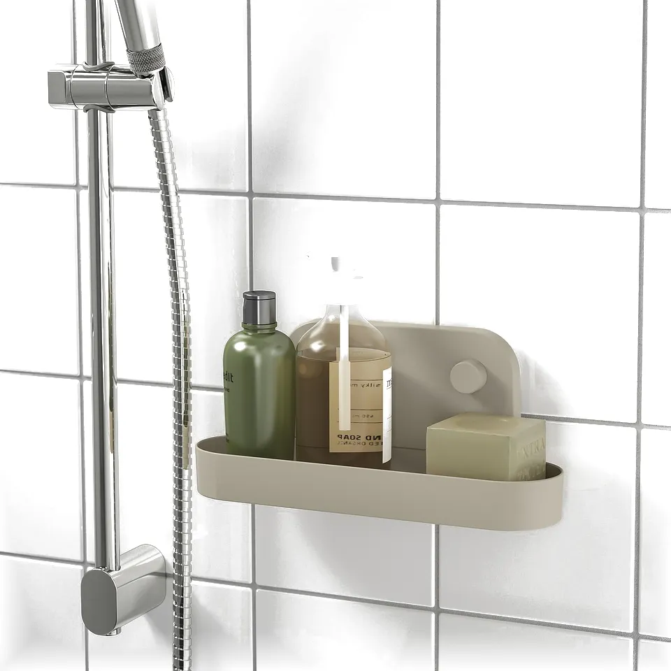 A bathroom shelf with suction cups holds bottles and soap near a shower head.