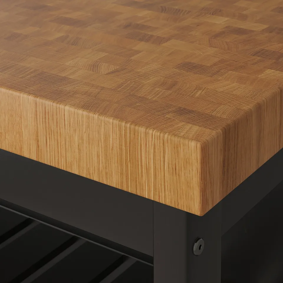 Close-up of high-quality oak butcher block countertop on modern kitchen island, showcasing natural wood grain and edge design.