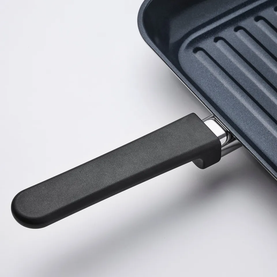 Black grill pan with non-stick coating and ergonomic phenolic plastic handle. High-quality, durable design.