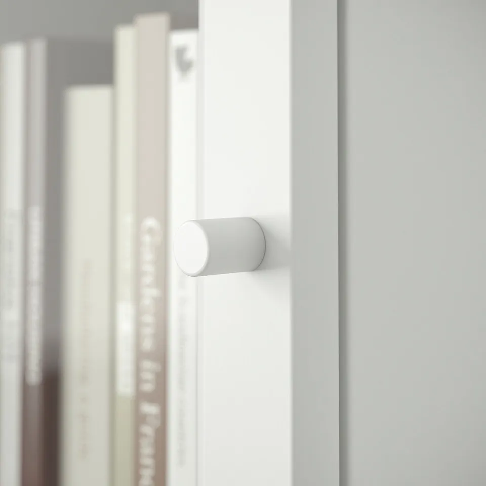 White cabinet with cylindrical handle, featuring clean design and smooth finish.