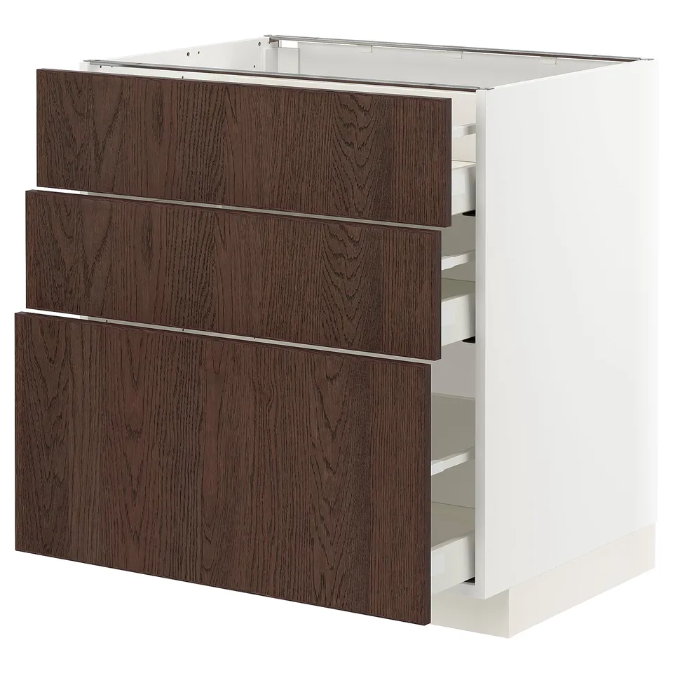 A white METOD kitchen cabinet with three dark brown wooden drawers featuring solid wood edges.