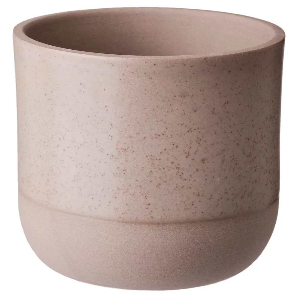 Round BUSKKAPRIFOL planter in pastel pink, speckled stoneware with a smooth, partially unglazed base.
