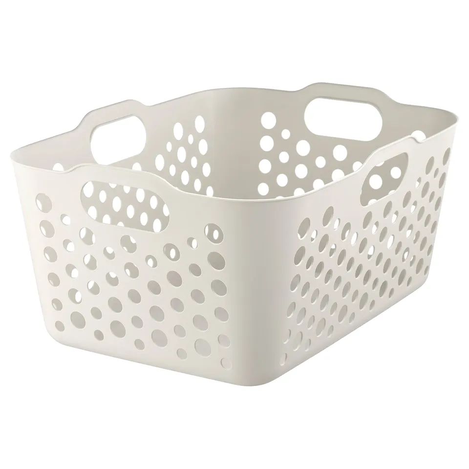 A white SLIBB laundry basket. Its made of plastic, handles on both sides and has a perforated design for ventilation.