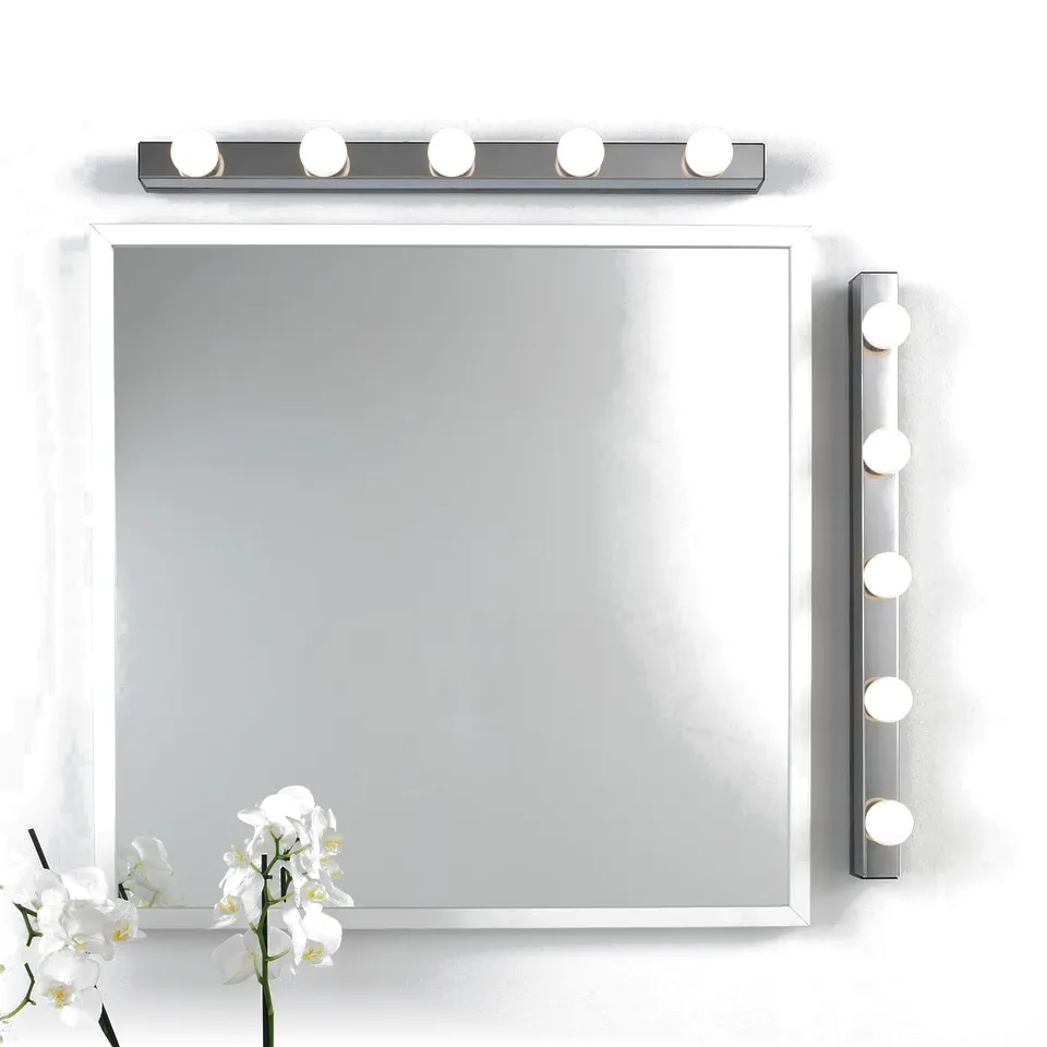 Mirror with vanity lights, one horizontal, one vertical. Flowers left.