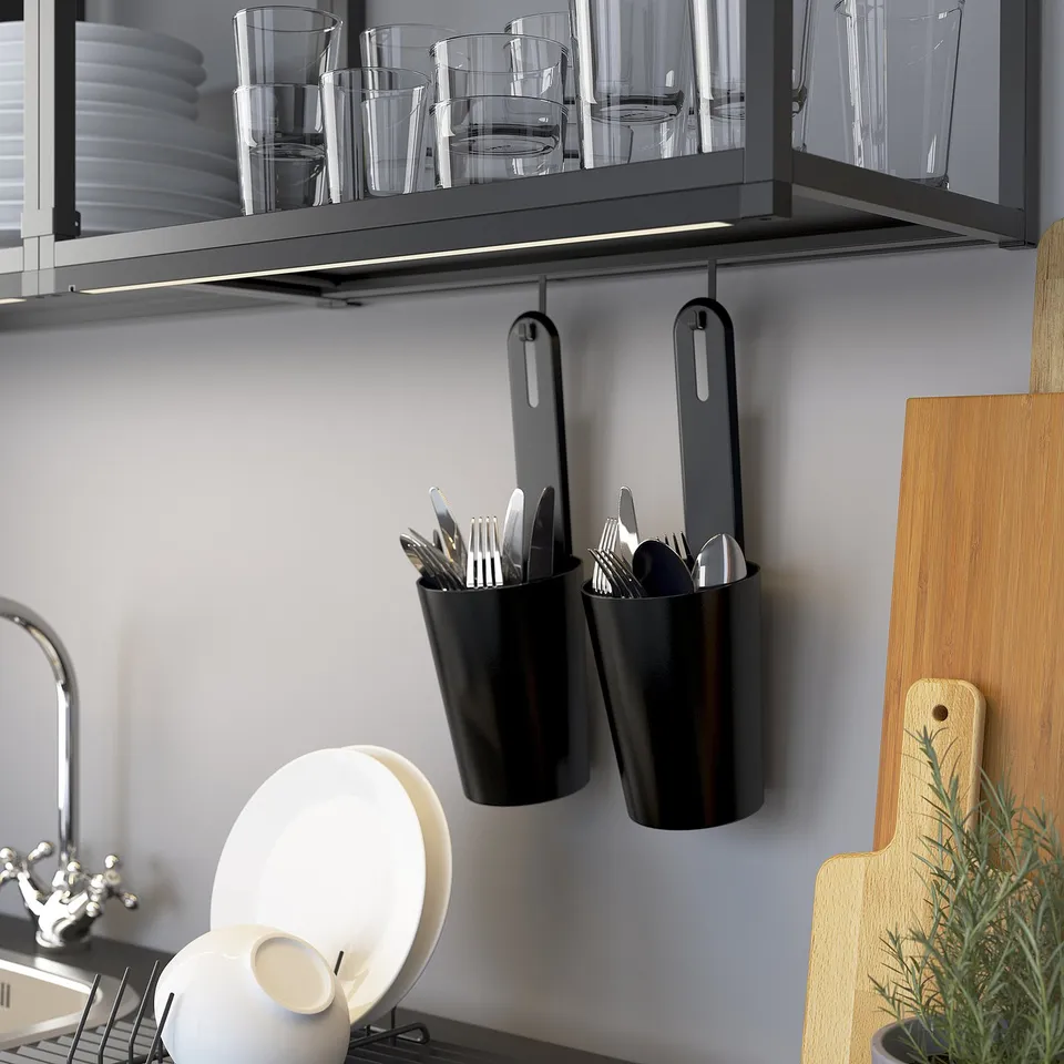 Kitchen organisation with ENHET. Glasses on top shelf, utensils in hanging pots, wooden cutting board nearby.