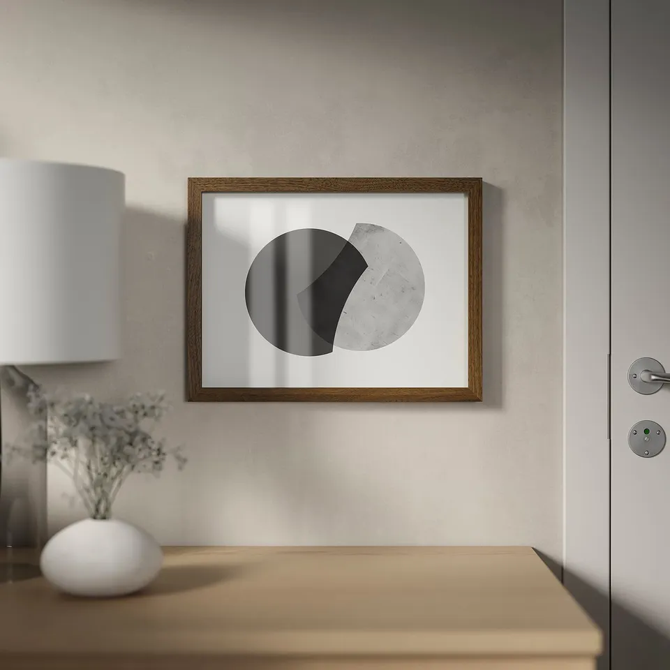 Wall-mounted frame with abstract art, near door and table with lamp and flowers.