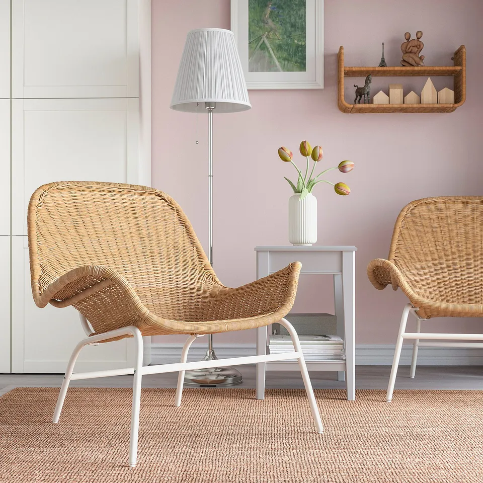 Wicker armchairs with metal legs in cosy room. Tulips, rug, lamp, shelf.