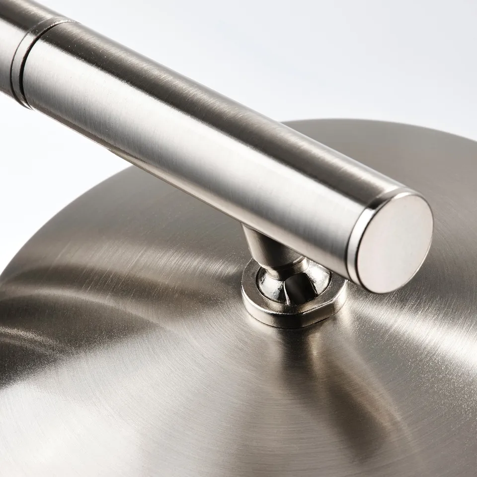 Close-up of modern lamp base, sleek nickel-plated steel, sturdy design.