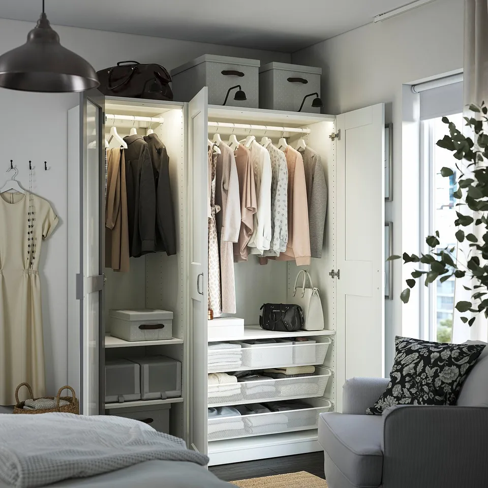 Organised wardrobe with clothes, shelves, boxes. Mirrored doors expand space. Built-in lighting.