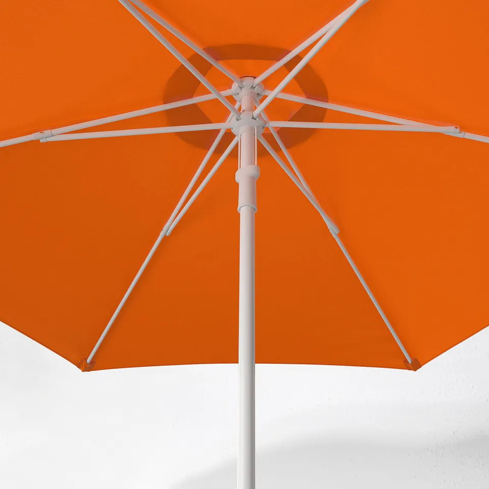 Bright orange sun umbrella with white frame and metal centre hub, open and vivid.
