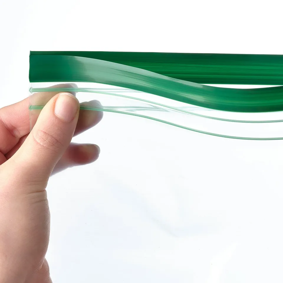 A hand holding a transparent, reusable green food storage bag, demonstrating its sealable and flexible nature.