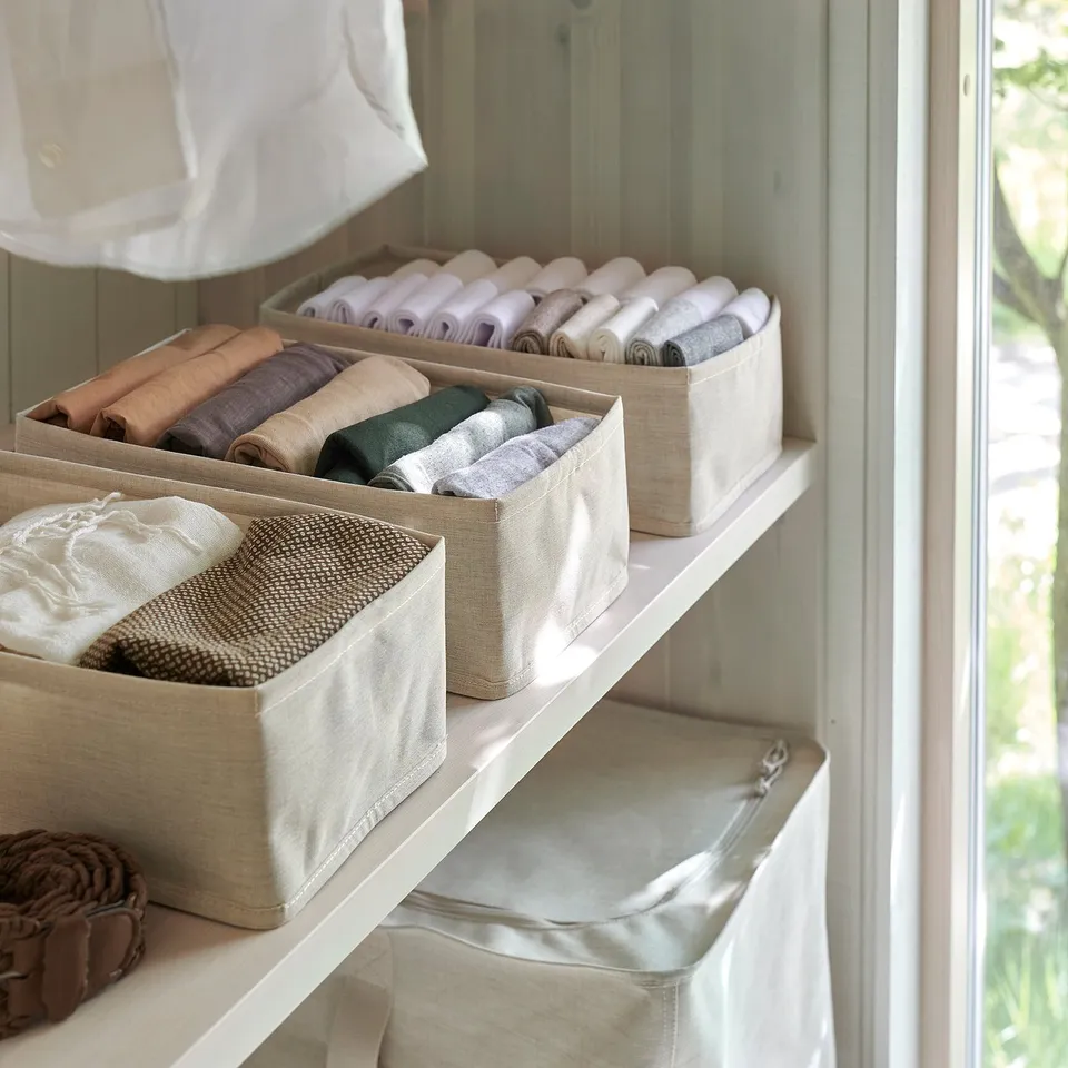 Organised closet with fabric bins for socks and accessories.