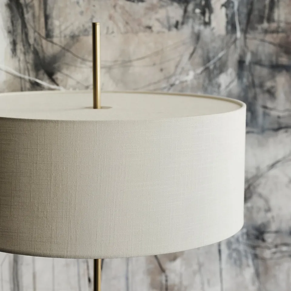 Luxury lamp with brass base and textured white shade, emitting warm light.