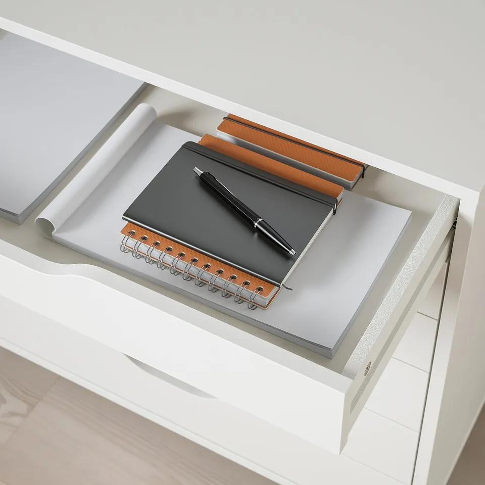 White desk drawer with notebook, pen, and notepad, showing storage and organisation for office supplies.