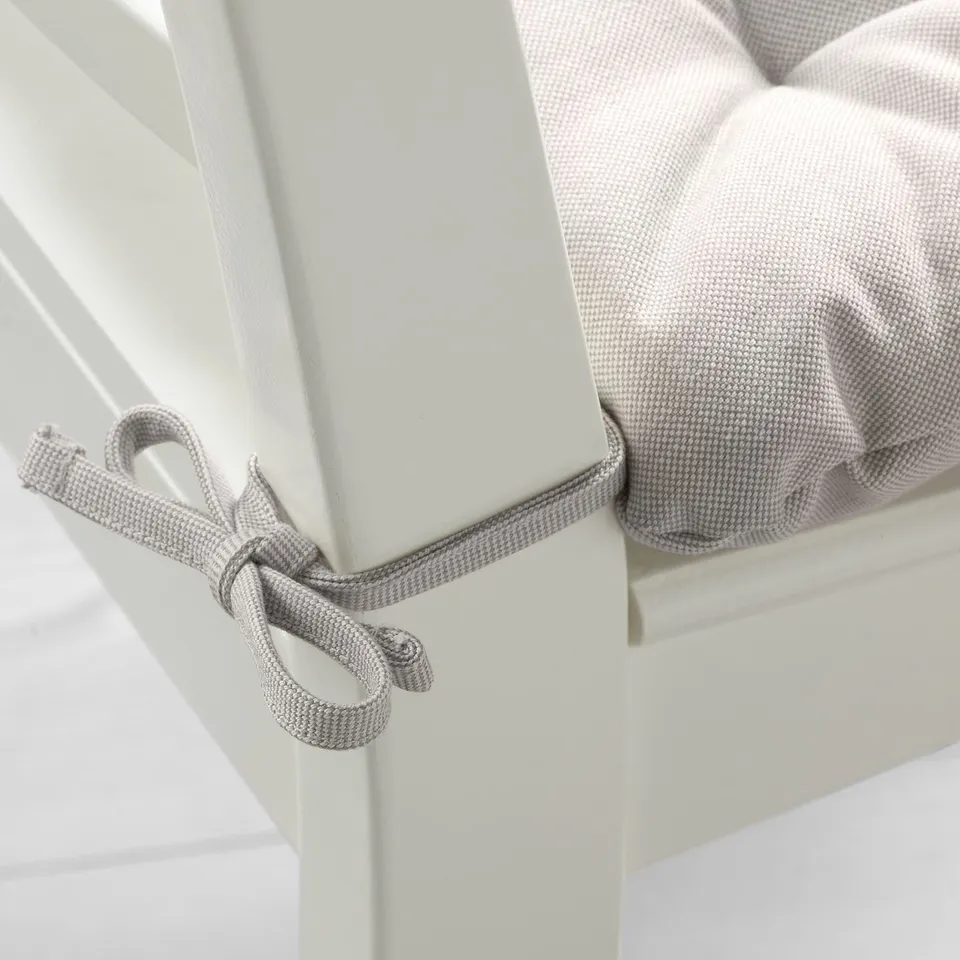 A cushioned chair pad with decorative ties, designed to fit perfectly on specific chairs.