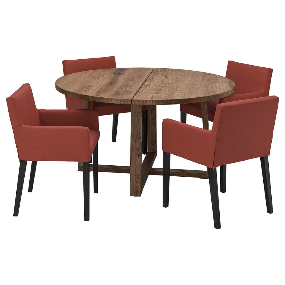Round wooden dining table with four red fabric chairs; modern & sturdy design.