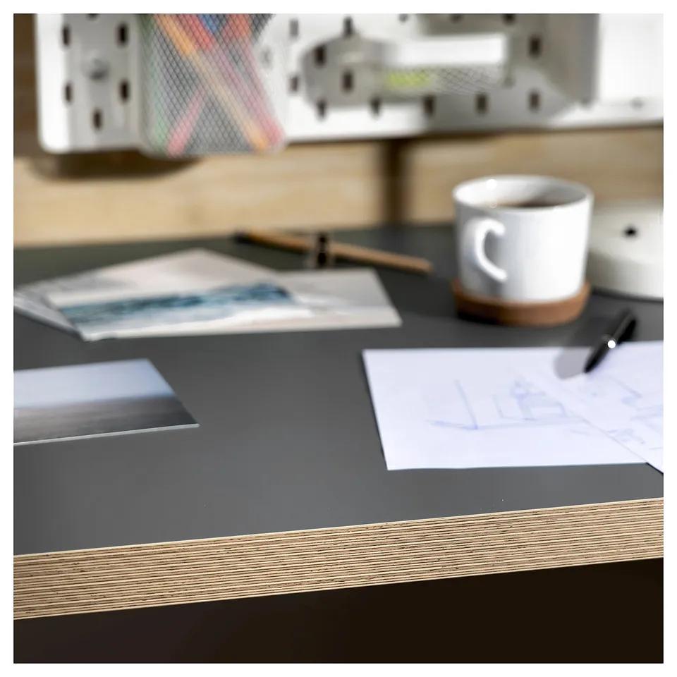 Modern desk setup with black LAGKAPTEN table, white mug, notepads, and pens.