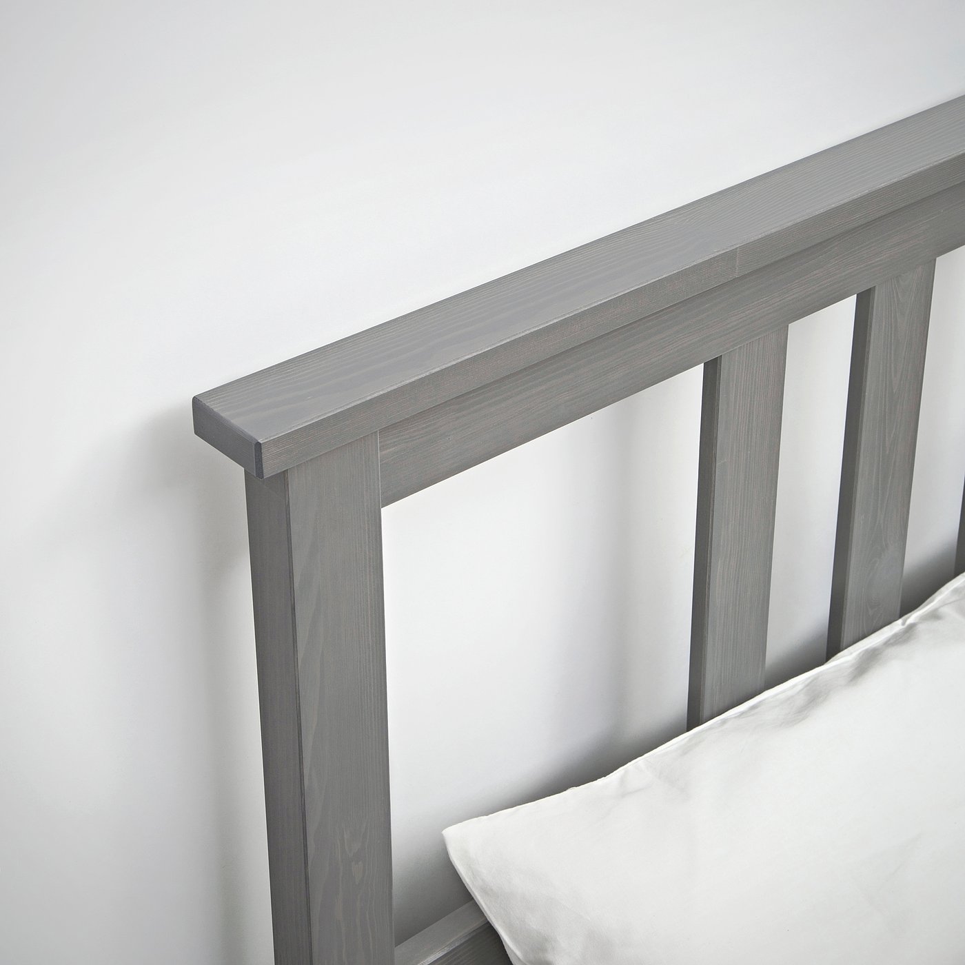 Modern grey wood bed frame, clean lines, comfortable pillow.
