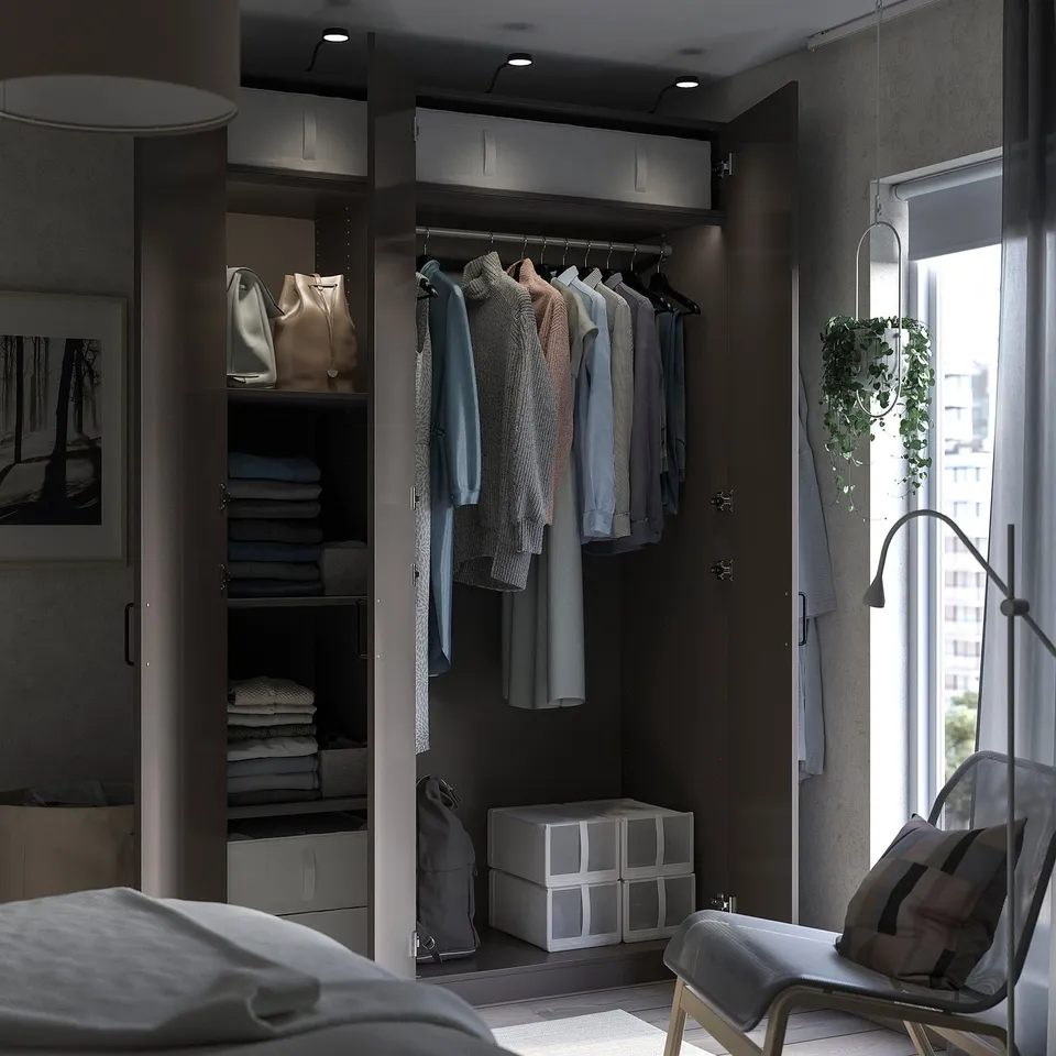 Modern bedroom with PAX wardrobe, grey shelves, chair, and plant.