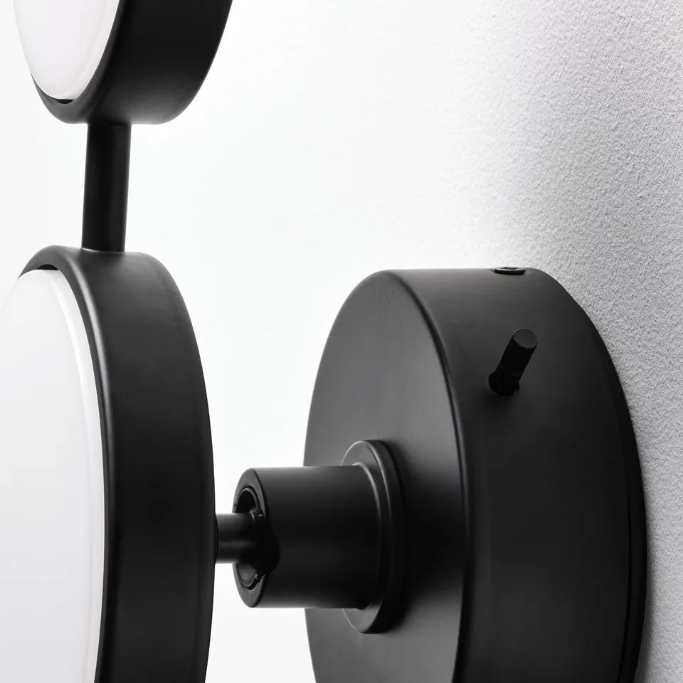 Modern black wall lamp with sleek design and built-in led bulb, mounted securely on a white wall.