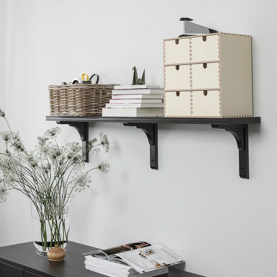 Shelf with drawers and storage: wall shelf holds books, basket, and decorations. Functional storage solution.