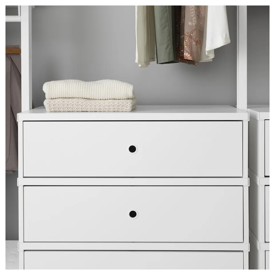 A white storage unit with two drawers and knitted textiles on top. Modern, clean design for organising clothes and items.