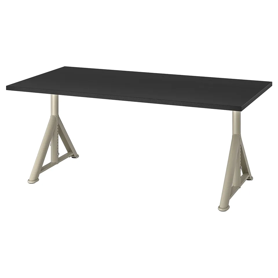 An IKEA IDÅSEN desk with a black top and adjustable silver legs. Its rectangular and has a modern, minimalist design with built-in cable management.
