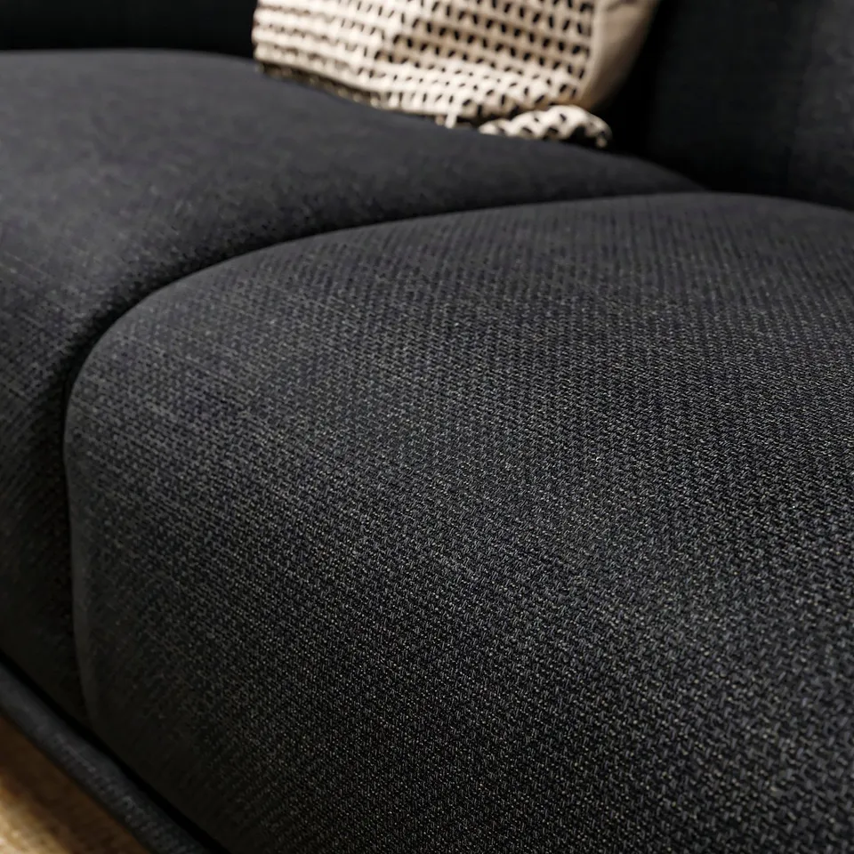 Black upholstered sofa with curved seat, deep cushions, and woven backrest. Soft, rounded shapes in modern design.