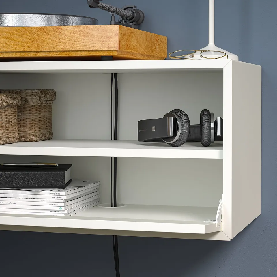 White wall-mounted shelf displaying books and tech gadgets. Includes listed items on EKET system.