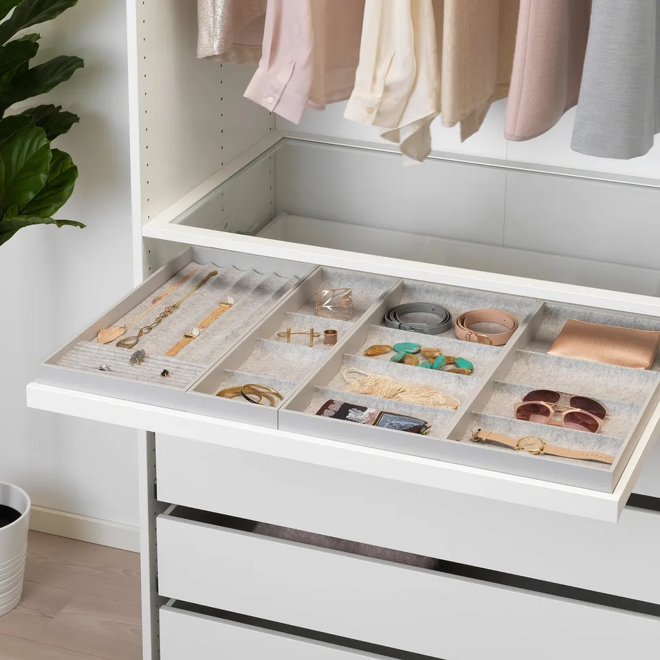 White drawer organiser with felt compartments for jewellery and accessories inside a wardrobe.