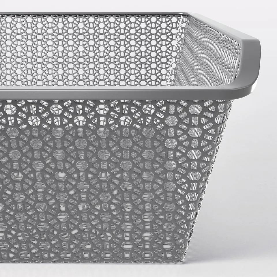 Metal storage basket with intricate cut-out patterns, featuring ventilation and a sleek, modern design. Ideal for organising clothes and accessories.
