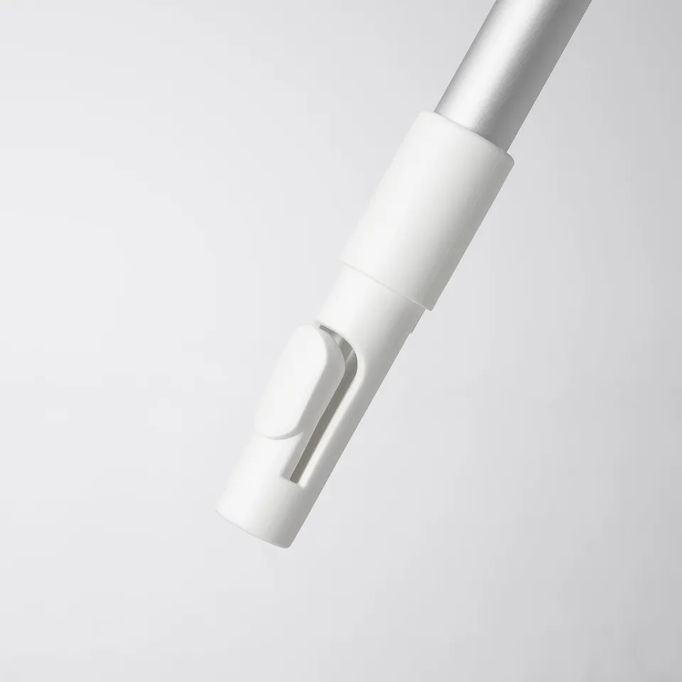 A sleek, white telescopic handle for cleaning, standing upright on a grey surface, showcasing its polished, durable design.