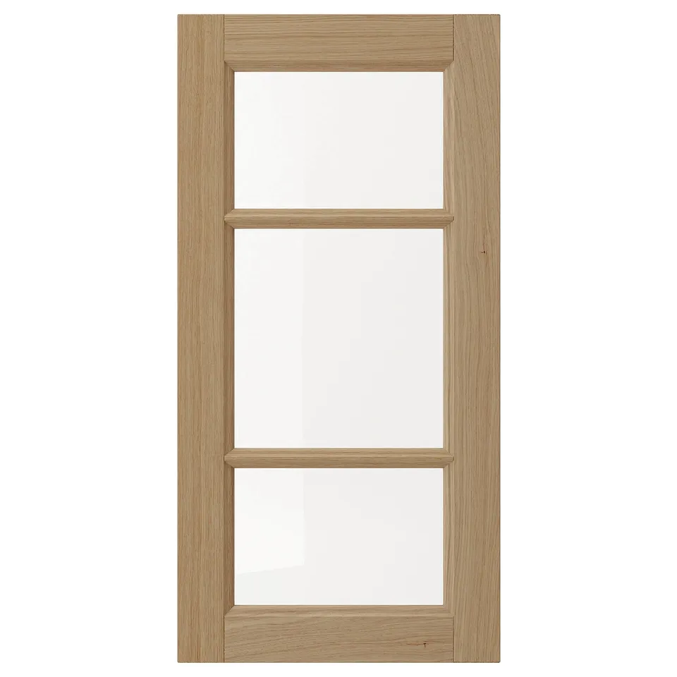 A VEDHAMN natural wood cabinet door with glass panels, featuring oak frames and a rectangular design.