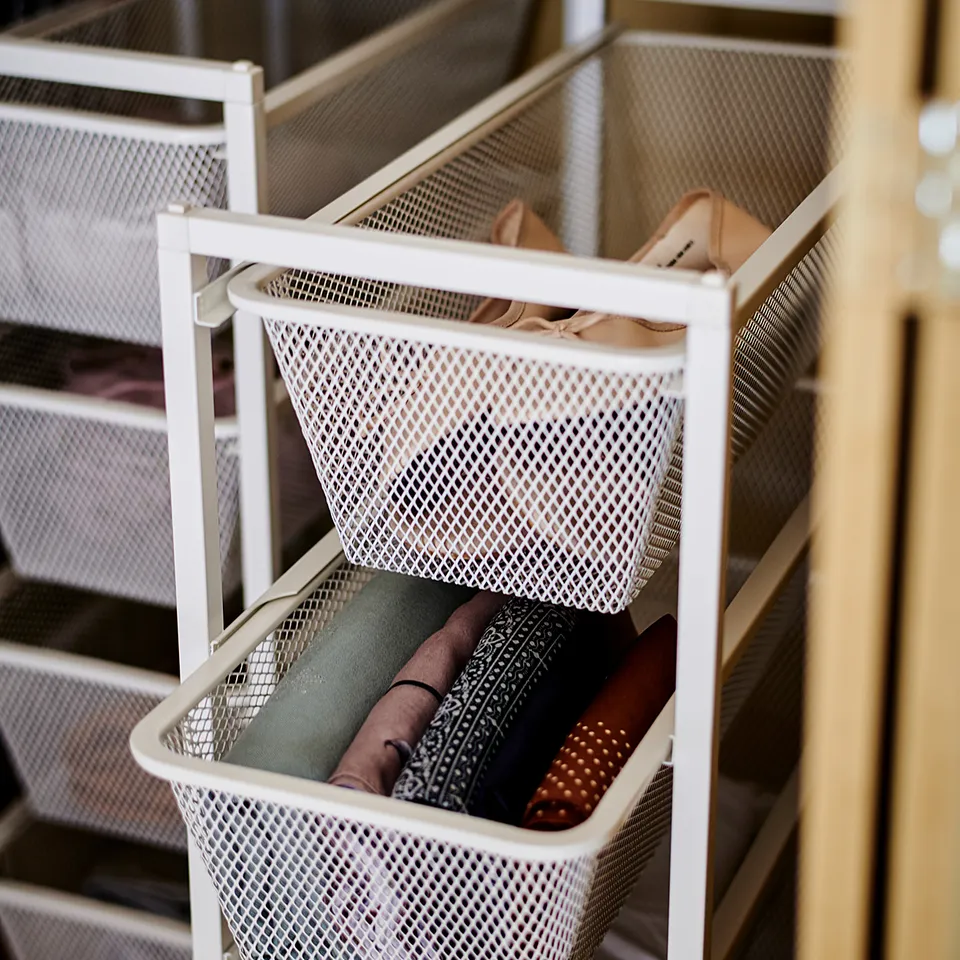 White JONAXEL mesh storage baskets holding folded clothes, neatly organised, perfect for air circulation and visibility.
