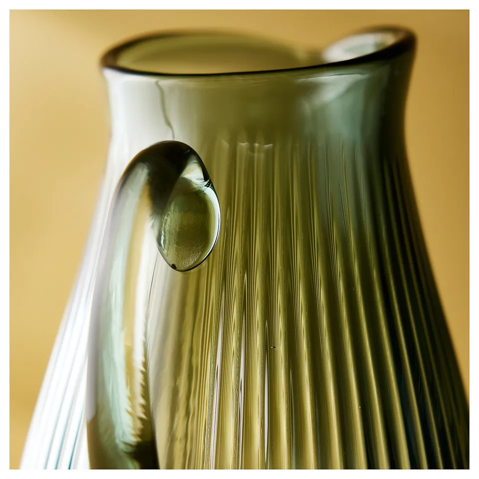 The VARDAGEN, a classic glass jug, stands beautifully. Its clear, ribbed texture and round handle make it elegant for any table.