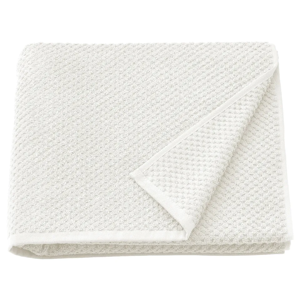 Folded beige GULVIAL cotton towel, soft & absorbent, 100% cotton, square shape, textured terry design.