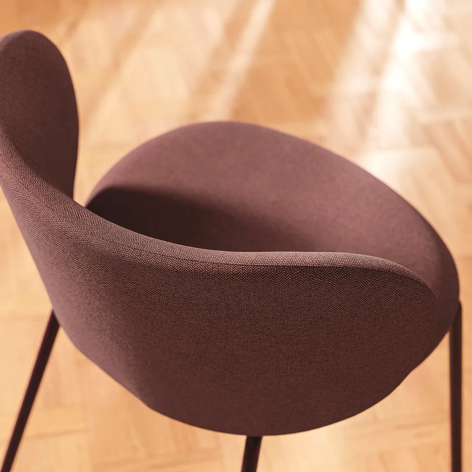 Upholstered chair with wingback support, dark brown fabric, and metal legs. Comfortable and stylish for dining.