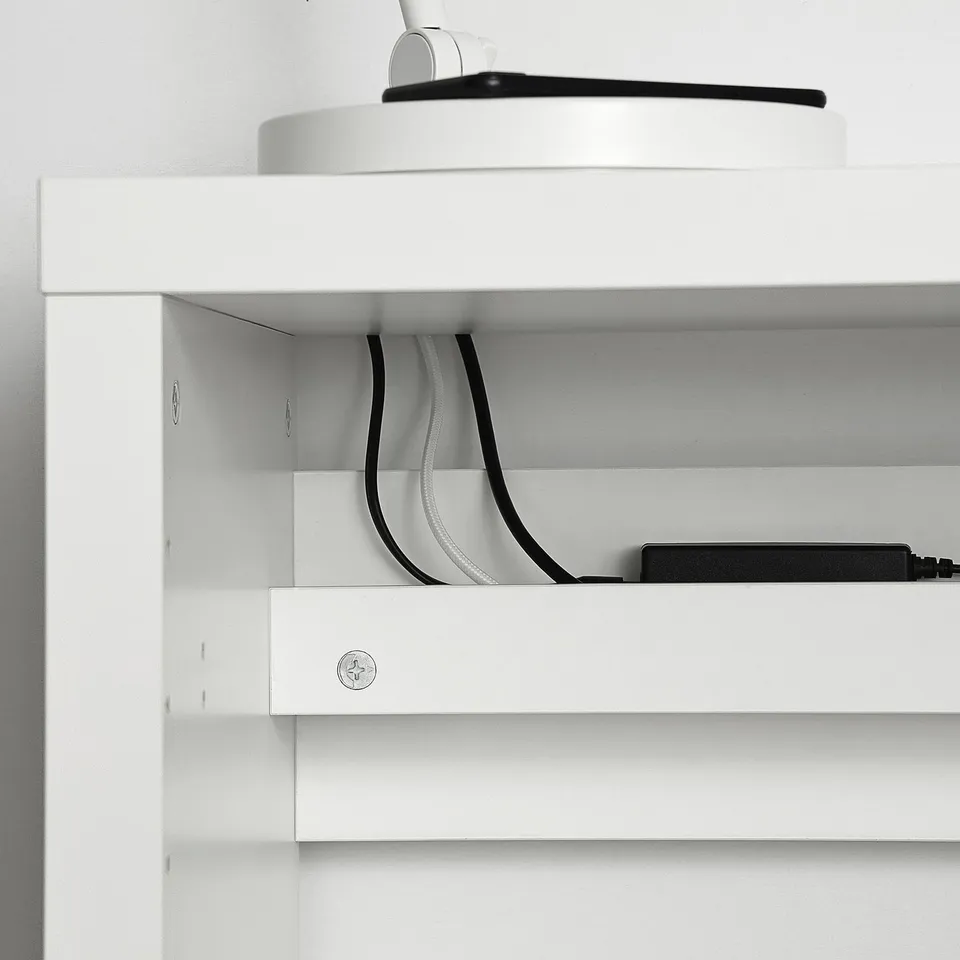 White KALLAX shelving unit with visible cable management and a device on top.