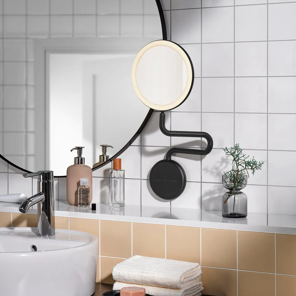 EKFÄNN mirror with lighting and magnifier on bathroom wall.