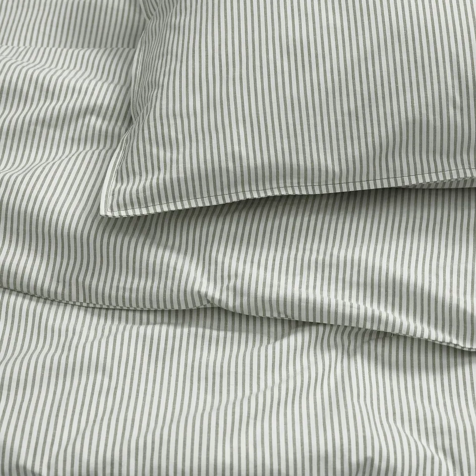Close-up of neatly folded striped bedding, showing crisp lines and even stitching, indicating high-quality cotton fabric.