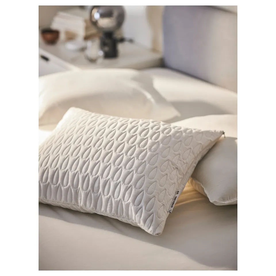 Bed with white SOTNÄTFJÄRIL pillow protector, patterned, with waterproof layer, soft wadding.