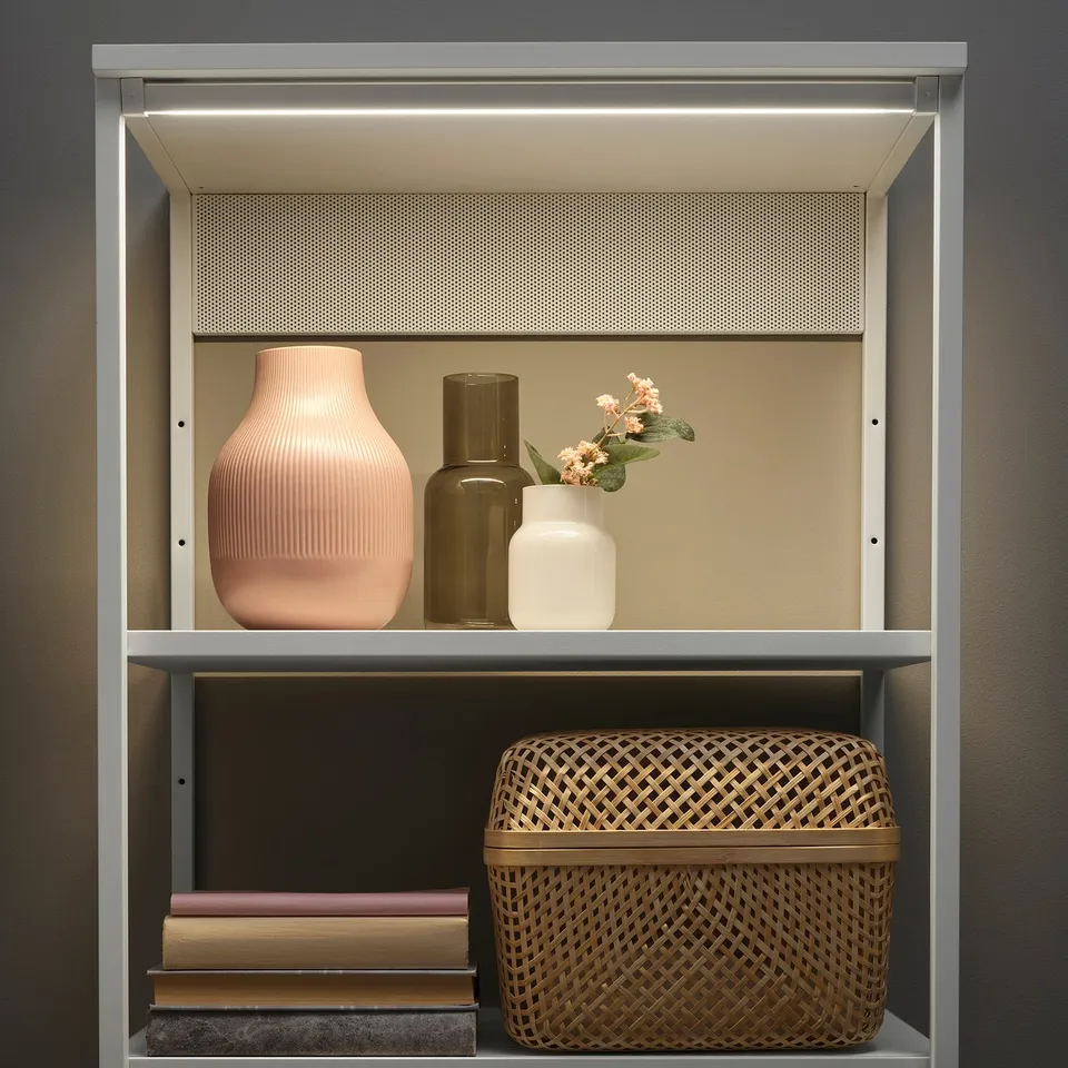 Modern shelving unit with integrated led lights, featuring vases and a basket.