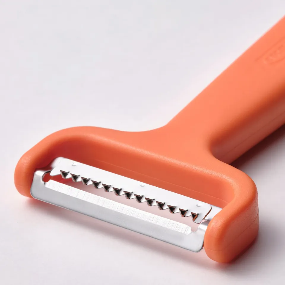 Orange vegetable peeler with sharp, stainless steel blades. Sturdy plastic handle for grip.