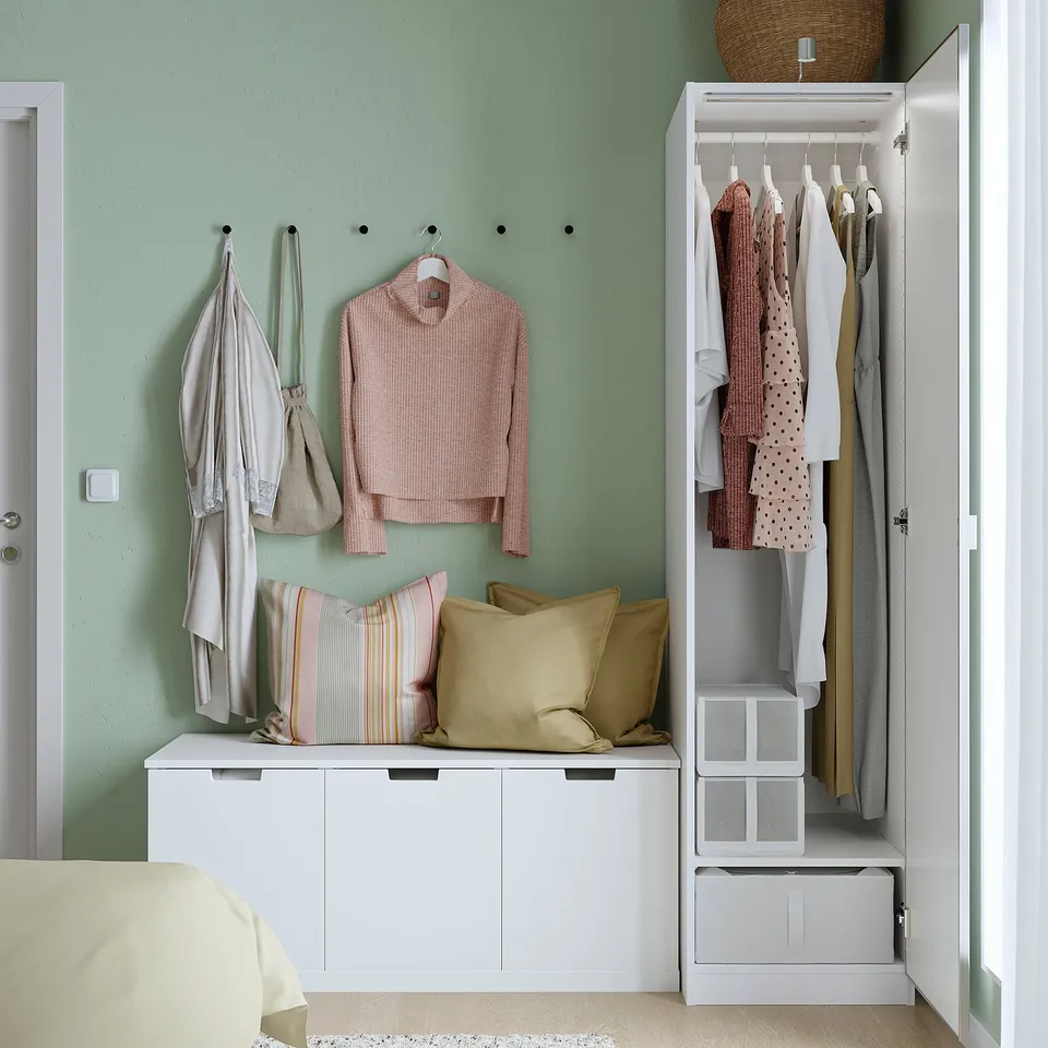 Modern bedroom with PAX closet, open doors showing clothes and storage.