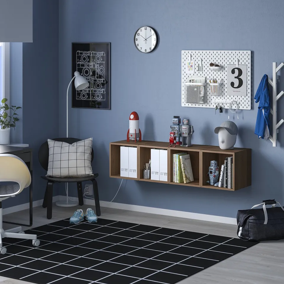 Wooden shelves with toys & books, blue wall, rug, backpack
