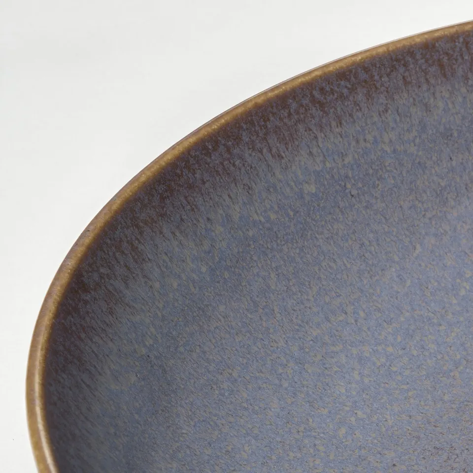 Blue glazed bowl, close-up on white.