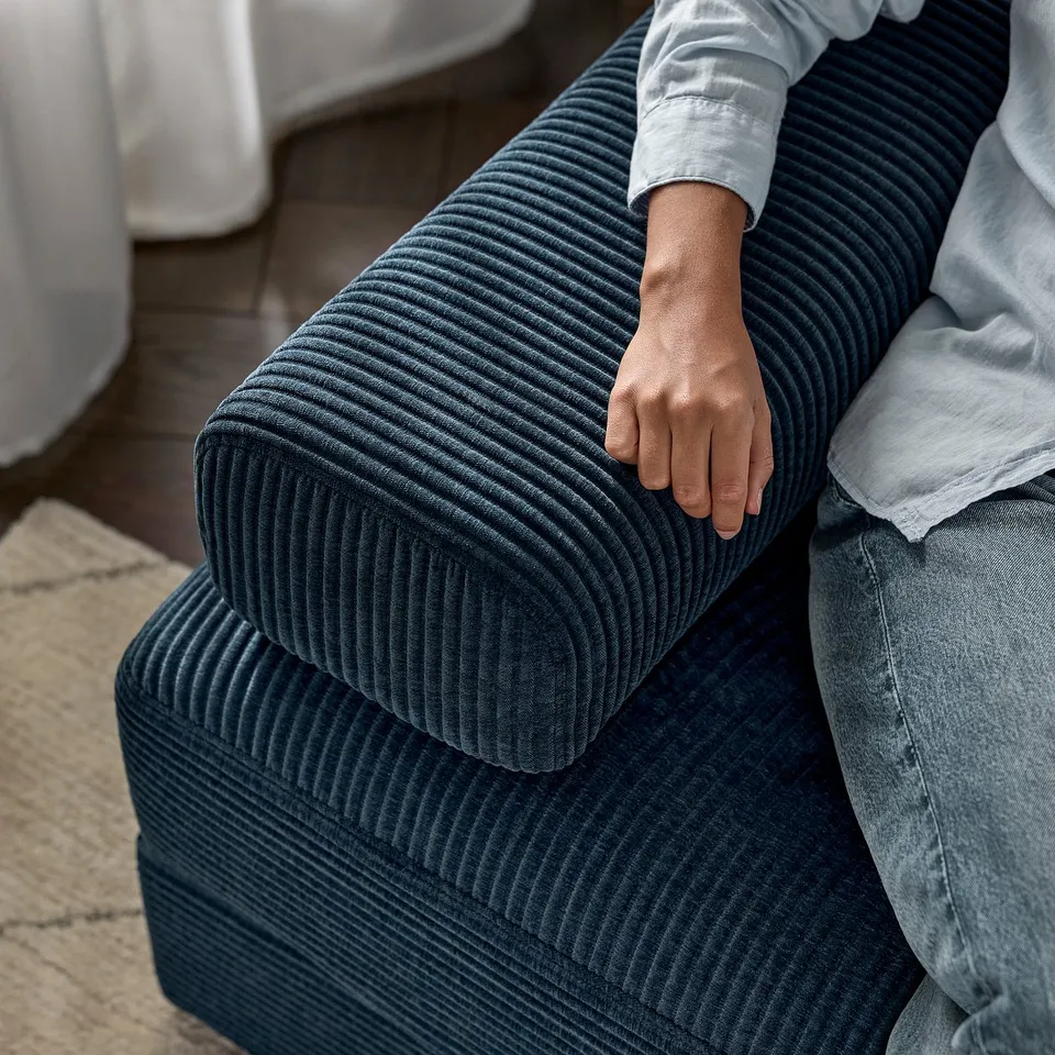 Person on JÄTTEBO sofa, showcasing comfortable foam and springs.